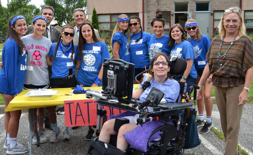 Screen_Shot_2019-02-18_at_12.55.52_PM Monmouth County Freeholders Pat Impreveduto and Gerry Scharfenberger (back row, left) join Holmdel High School athletes, LADACIN Executive Director, Patricia Carlesimo, and Denise, a former client and employee at LADACIN Network’s Schroth School carnival.