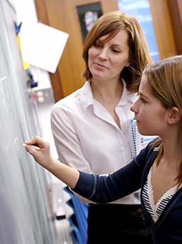 ASAH IS Its Members - female private special education teacher working one-on-one at the blackboard with a female student